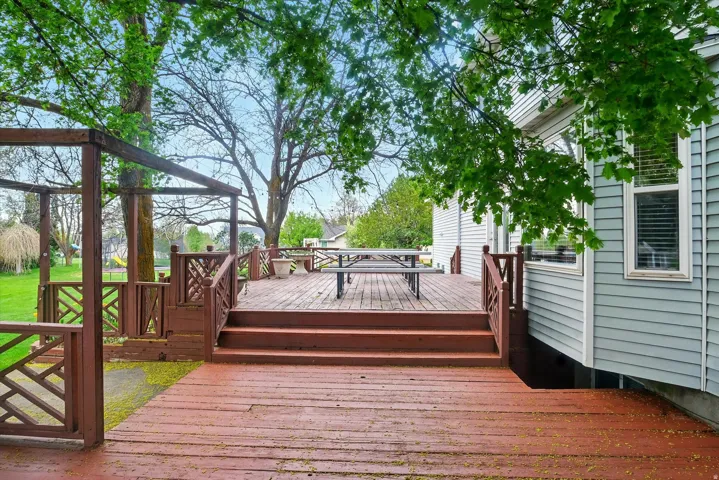 Multi-level wood deck featuring a pergola structure and decorative railing