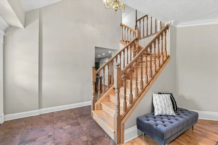 Two-story staircase featuring wood balusters and handrails