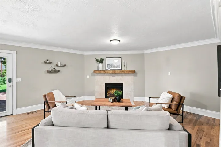Light-toned fireplace with stone surround and wood mantel