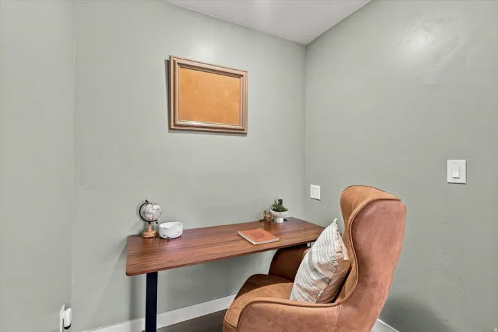 Dedicated workspace featuring a wood-finish desktop, light green walls, and white trim molding