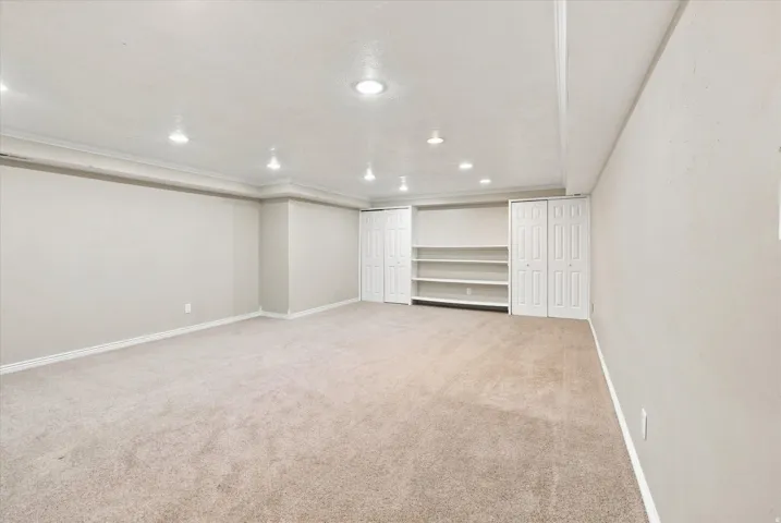 Spacious room featuring neutral carpeting and recessed lighting