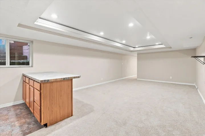 Expansive room featuring recessed lighting within a tray ceiling