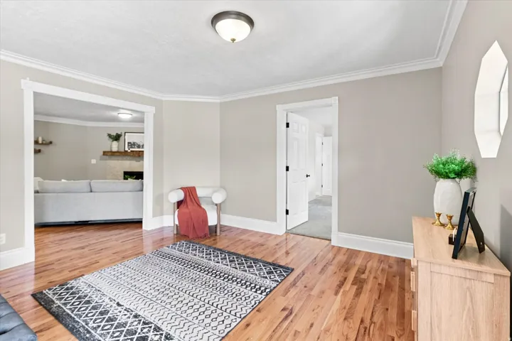 Hardwood-finish flooring throughout the space, complemented by neutral wall tones and white crown molding