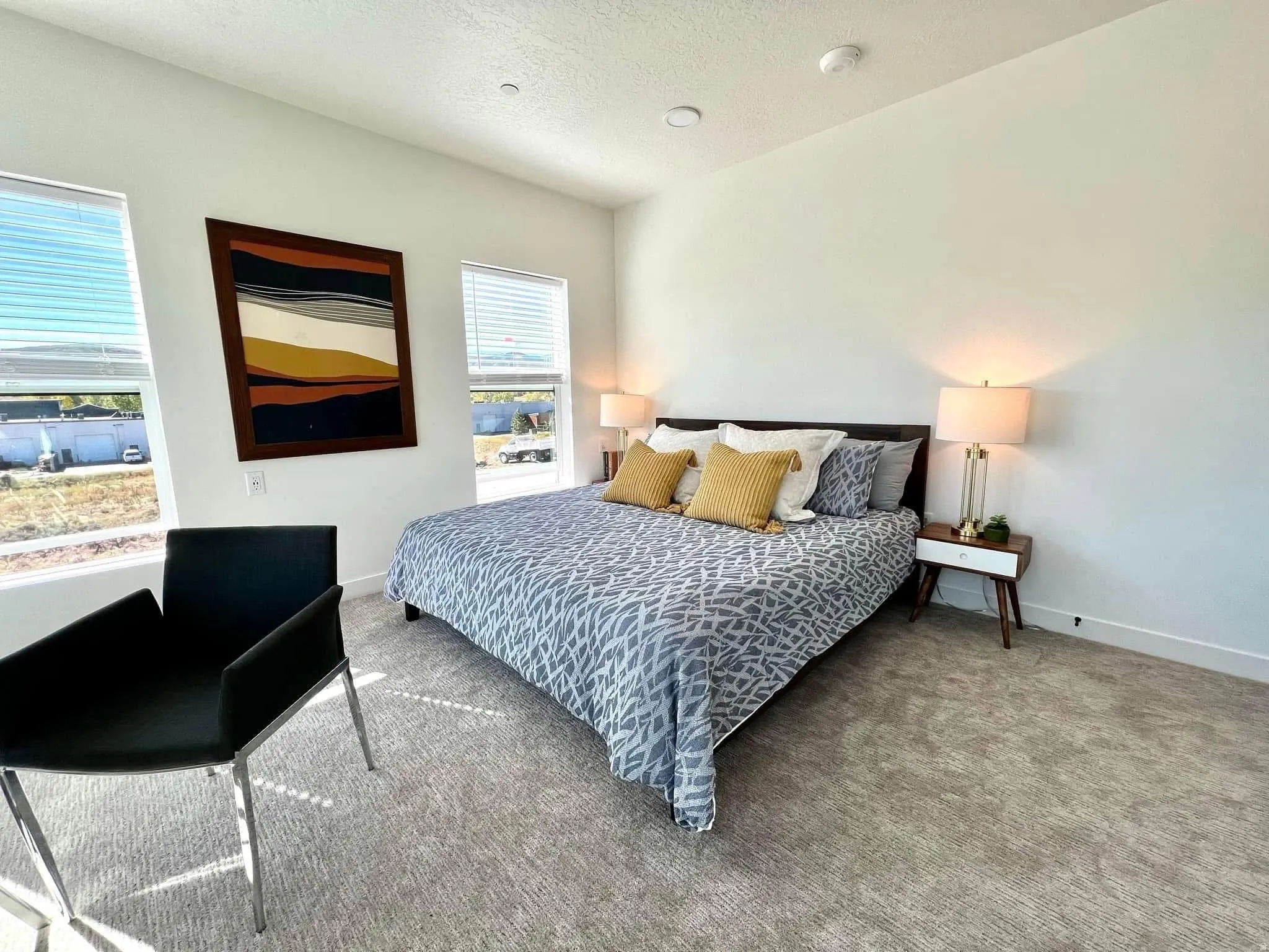 Expansive bedroom featuring dual windows with blinds, recessed lighting, and light-tone carpeting