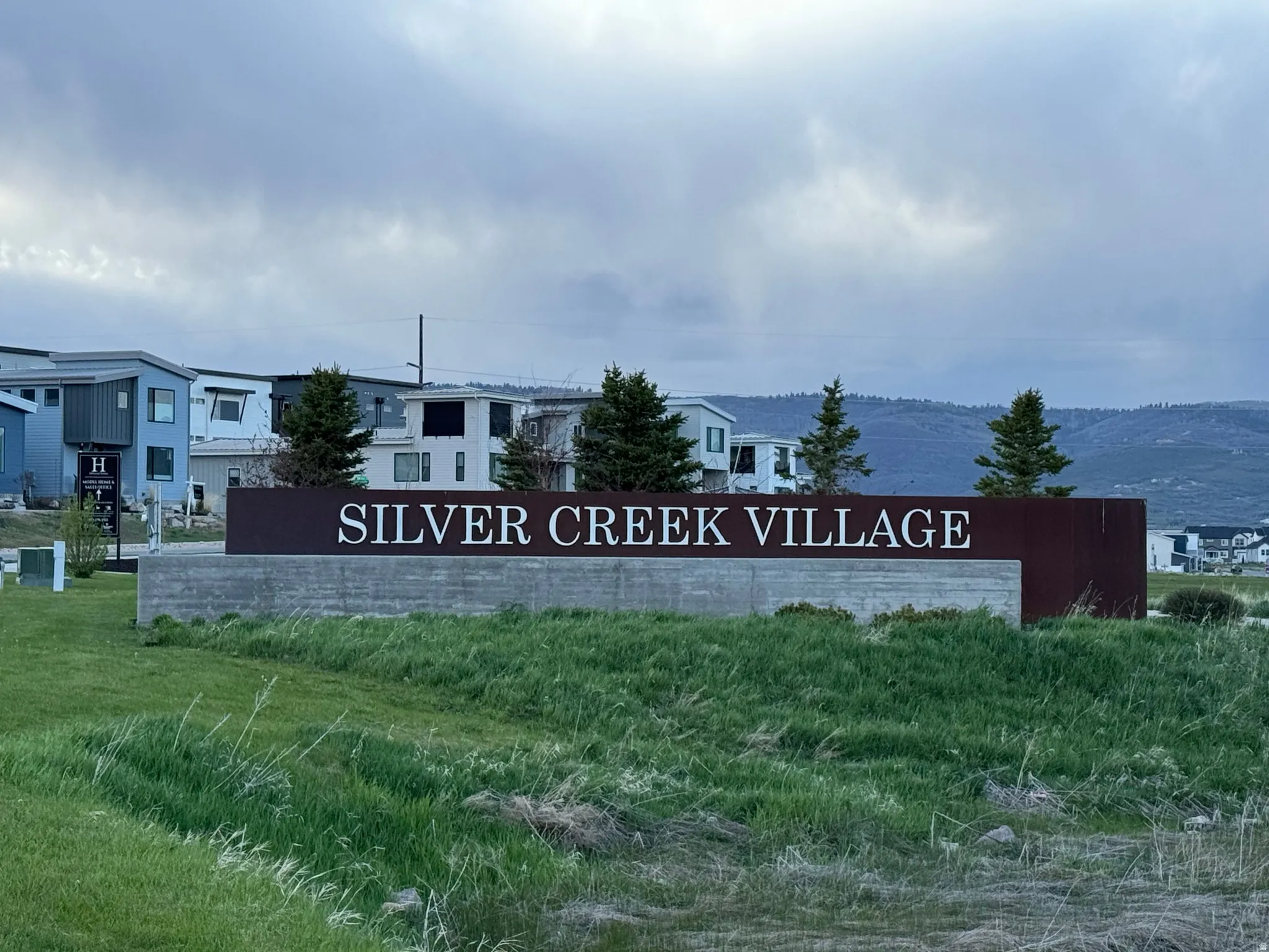 "Silver Creek Village" signage featuring a modern design with white lettering on a dark panel, set on a concrete base