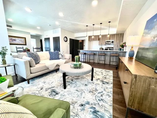 Open-concept living space featuring wood-finish flooring, recessed lighting, and a modern kitchen