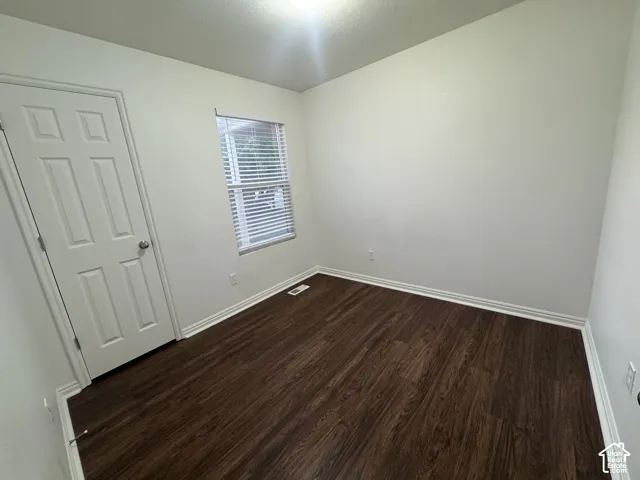 Room featuring wood-finish flooring, white baseboards, and neutral wall tones