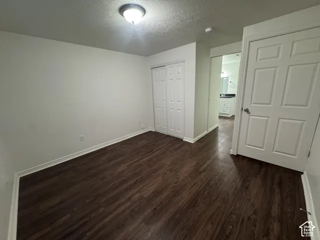 Room featuring wood-finish flooring, white baseboards, and a flush-mount ceiling light