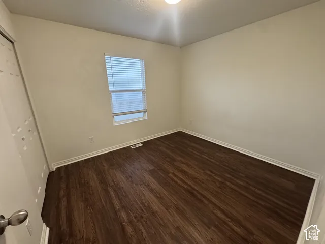 Room featuring wood-finish flooring, white baseboards, and neutral wall paint