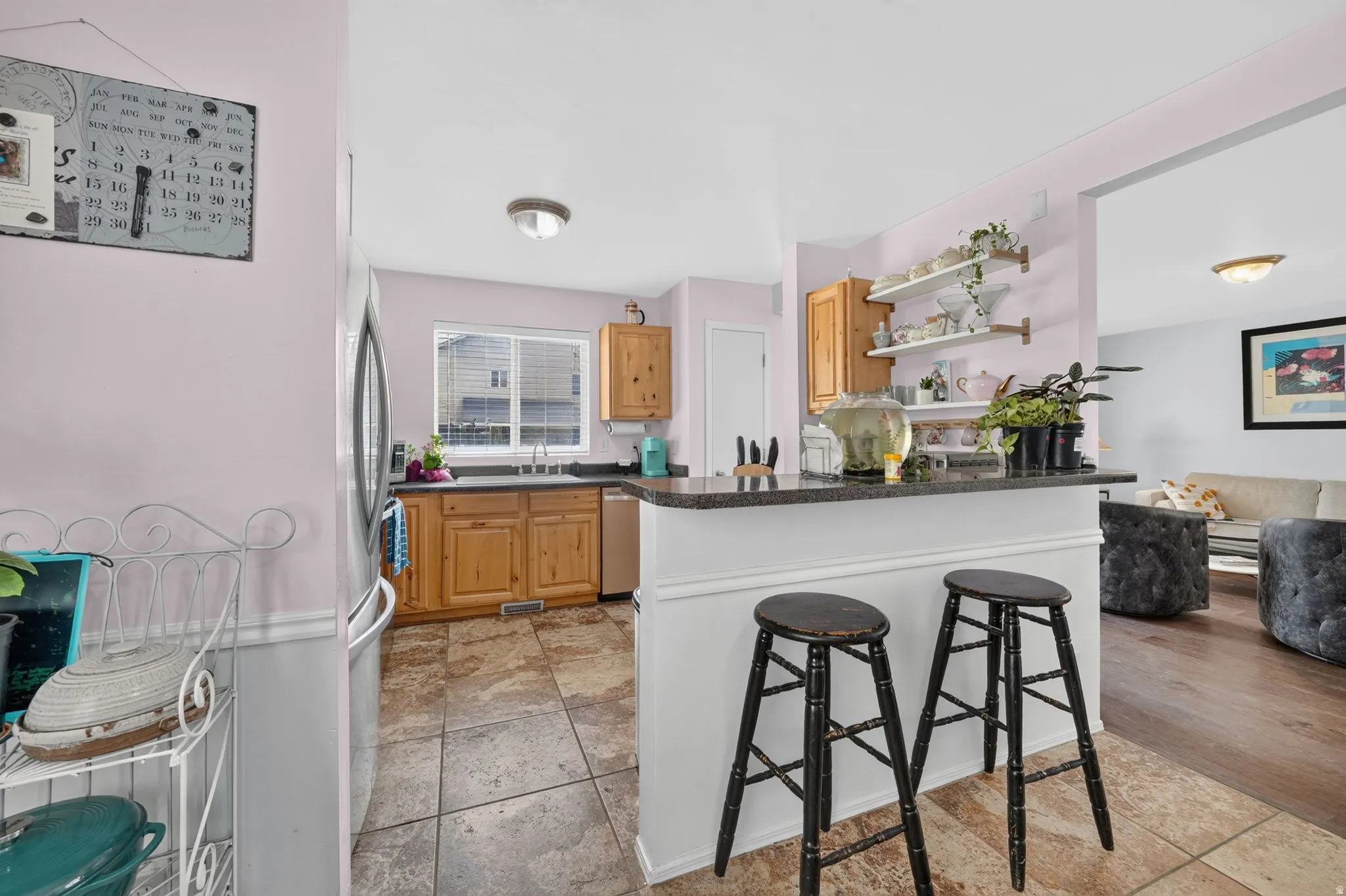 Kitchen featuring granite-style countertops, wood cabinetry, and a stainless steel sink