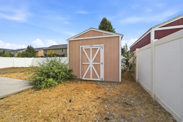 Freestanding shed with a gabled roof and white trim accents