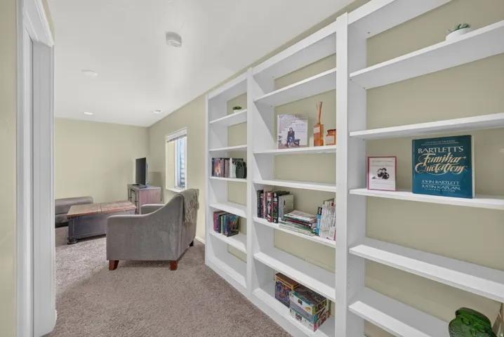 Built-in white shelving system with recessed lighting and neutral-toned walls