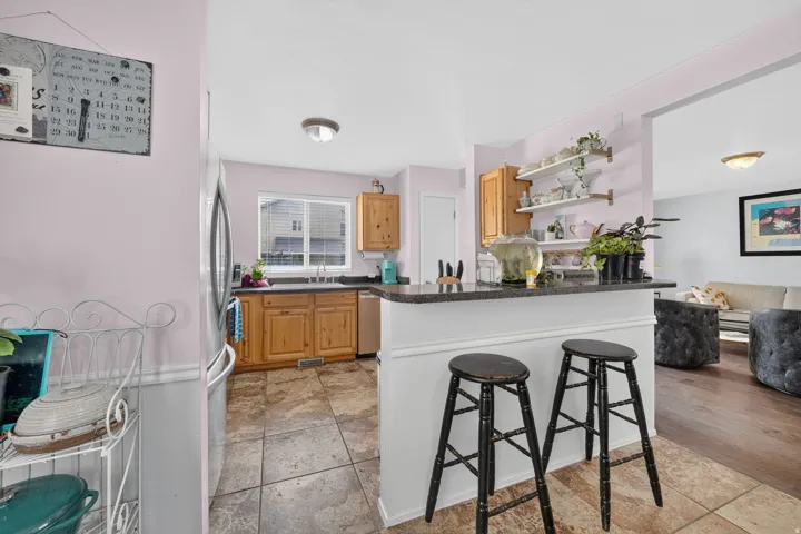 Kitchen featuring granite-style countertops, wood cabinetry, and a stainless steel sink