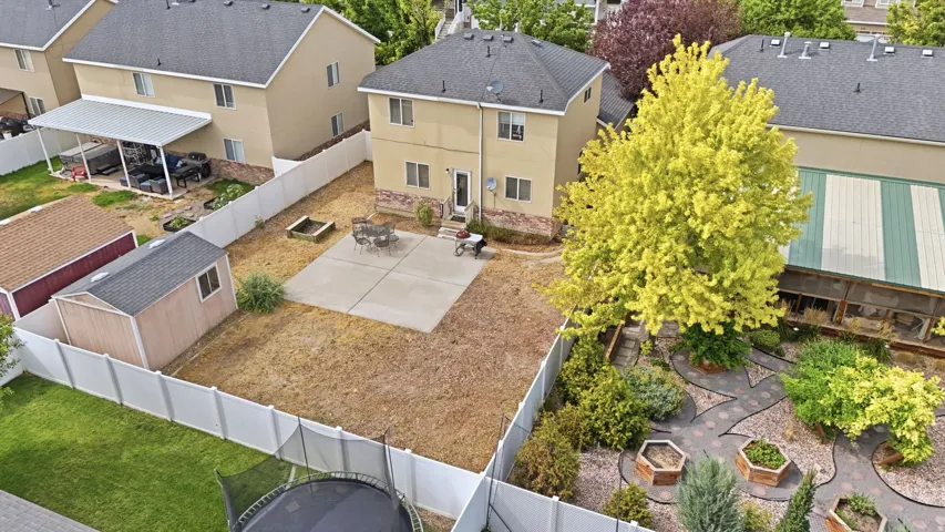 Rear exterior featuring a concrete patio, a detached storage shed, and a privacy fence