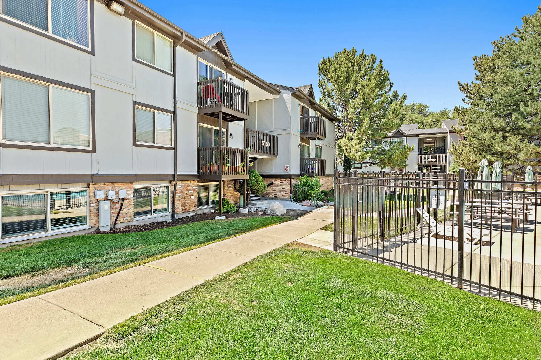 Multi-story apartment building with light-colored siding and dark trim