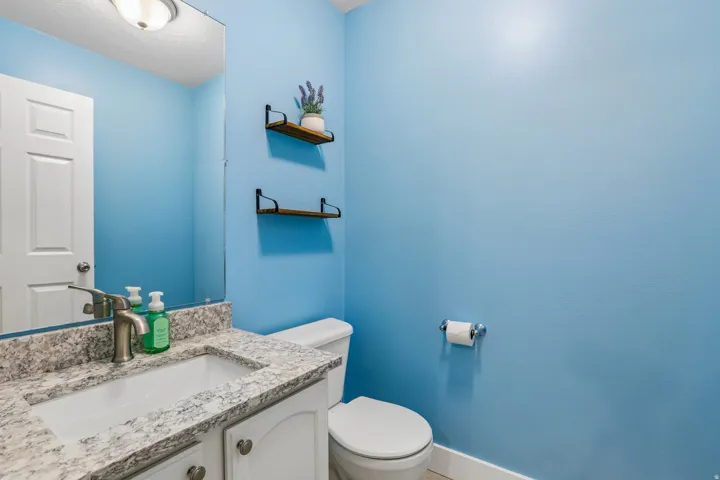 Bathroom featuring a vanity with an integrated white sink, a speckled countertop, and a brushed nickel faucet