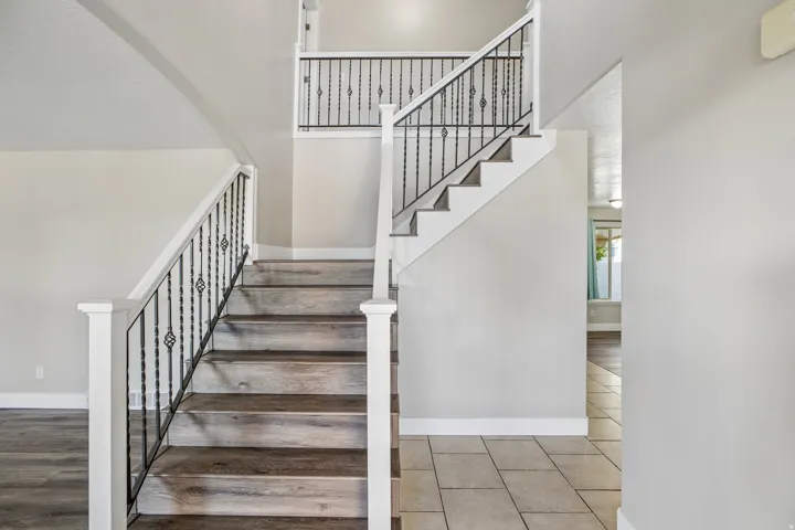 Grand entryway featuring a staircase with wood-finish treads and wrought iron balusters