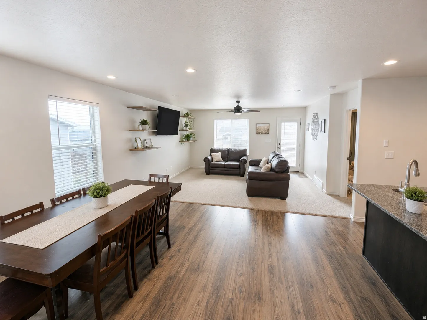 Open-concept living area featuring wood-finish flooring, recessed lighting, and a neutral color palette