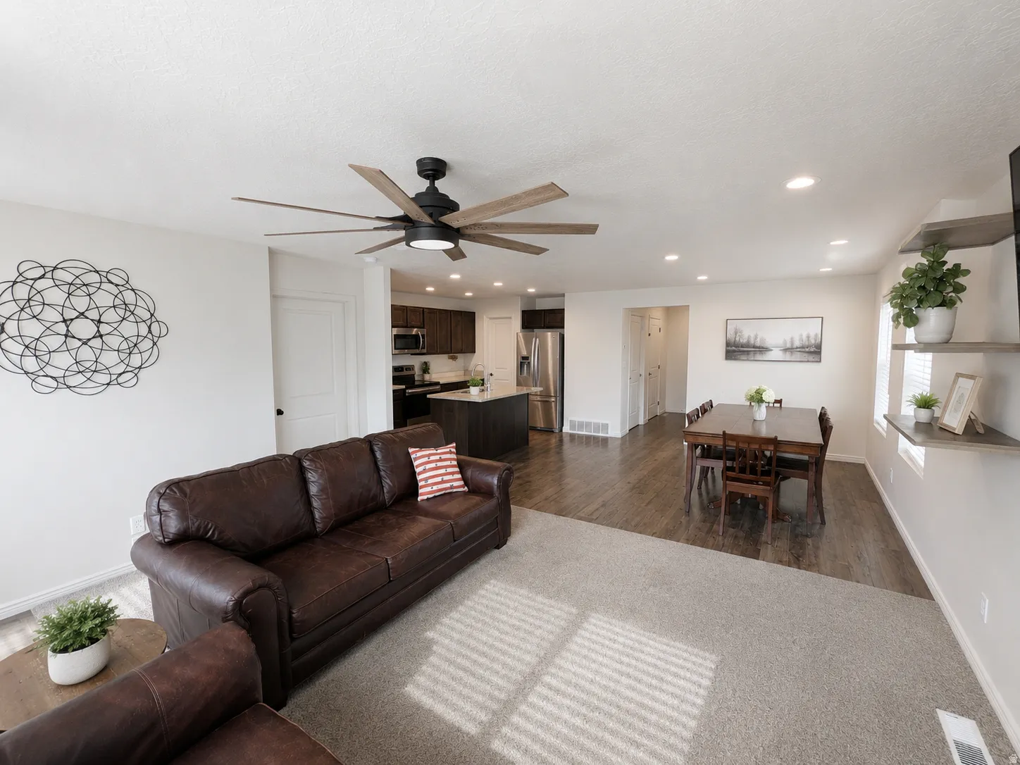 Bright living area featuring a ceiling fan with integrated lighting, recessed lighting, and wall-to-wall carpeting