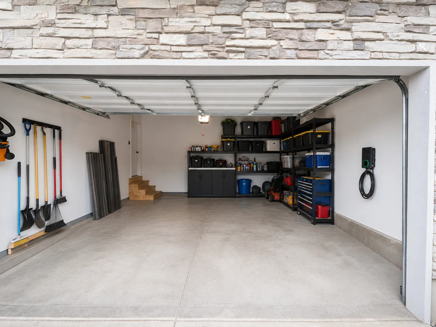Spacious two-car garage featuring a light gray concrete floor and white walls