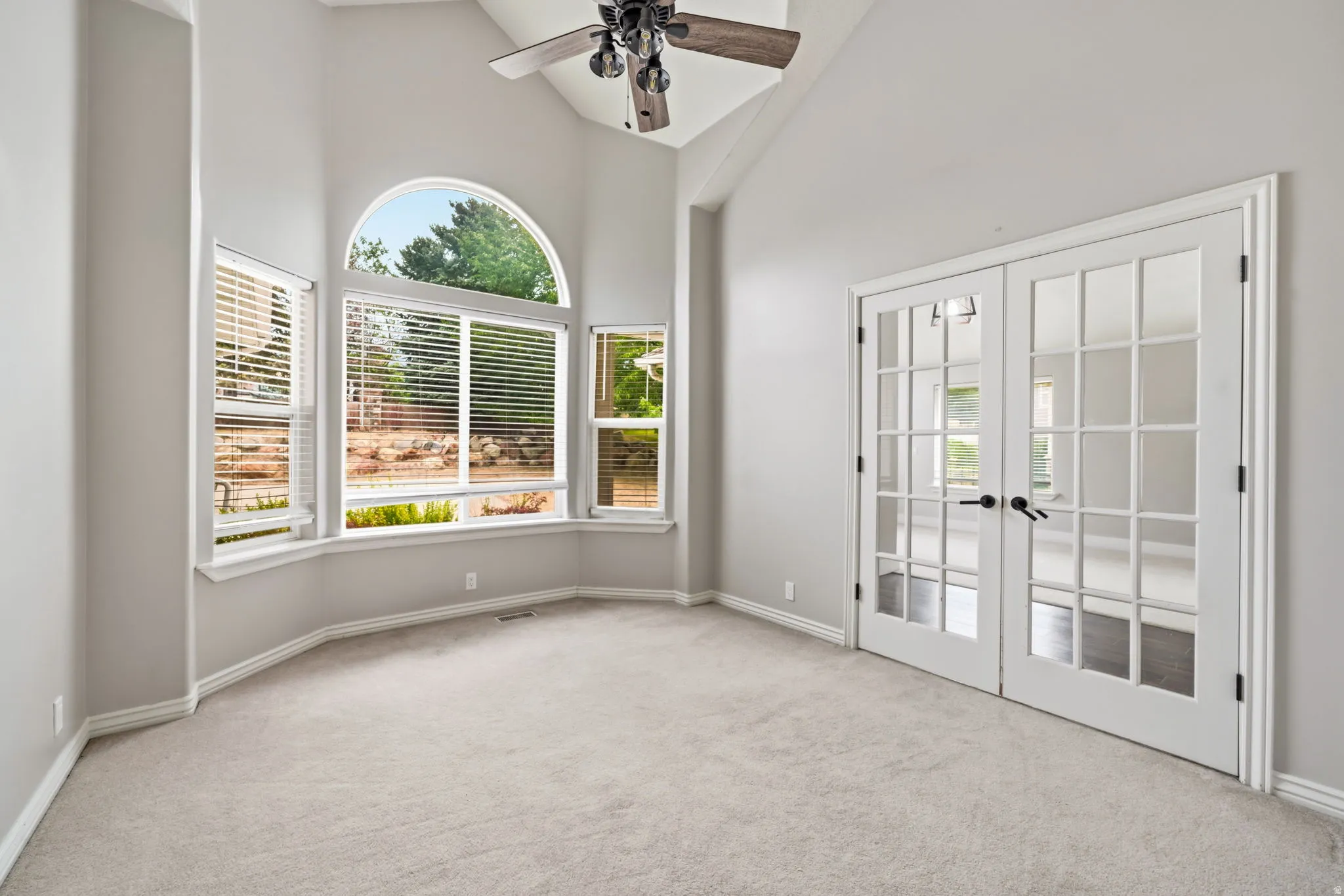 Room featuring vaulted ceilings and a ceiling fan
