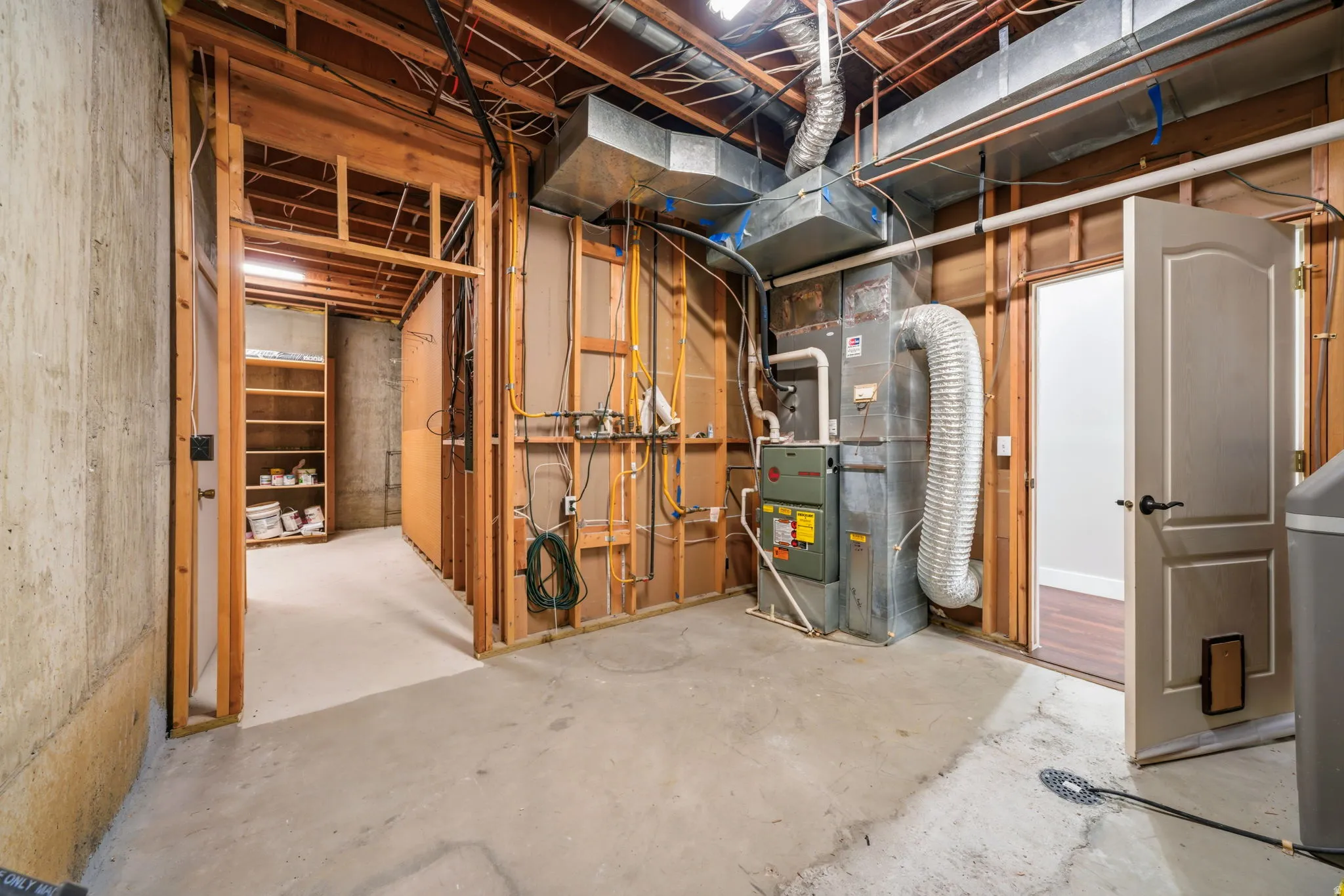 Unfinished basement space with exposed concrete foundation walls and a concrete floor