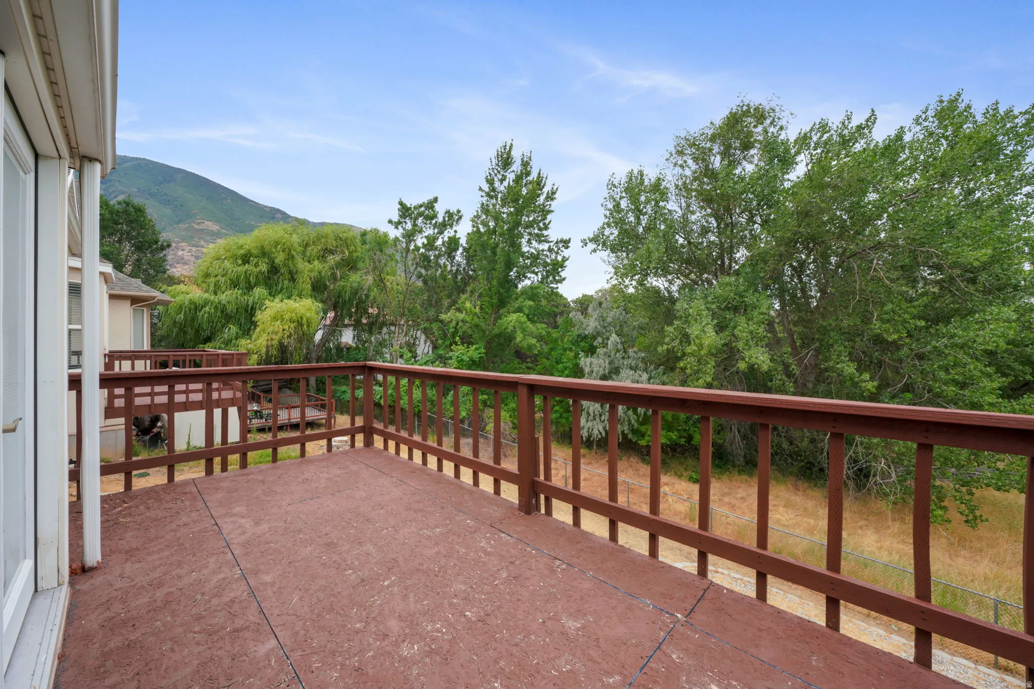 Expansive outdoor deck featuring a brown wood-finish surface and matching railings