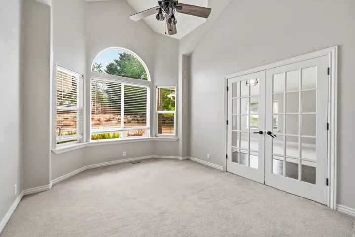Room featuring vaulted ceilings and a ceiling fan