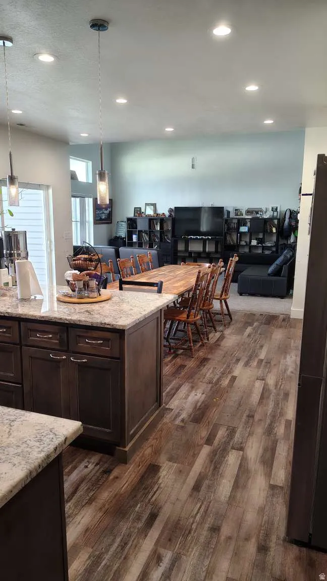 Kitchen island with stone-finish countertops and dark wood-finish cabinetry