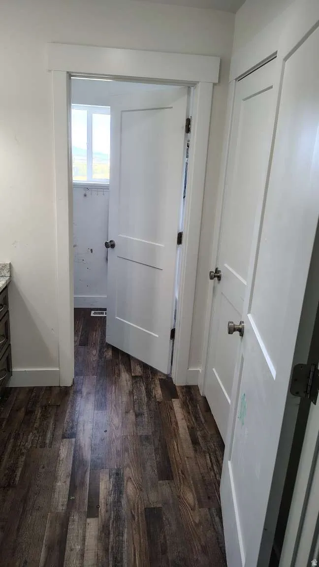Wood-finish flooring with white trim and paneled doors