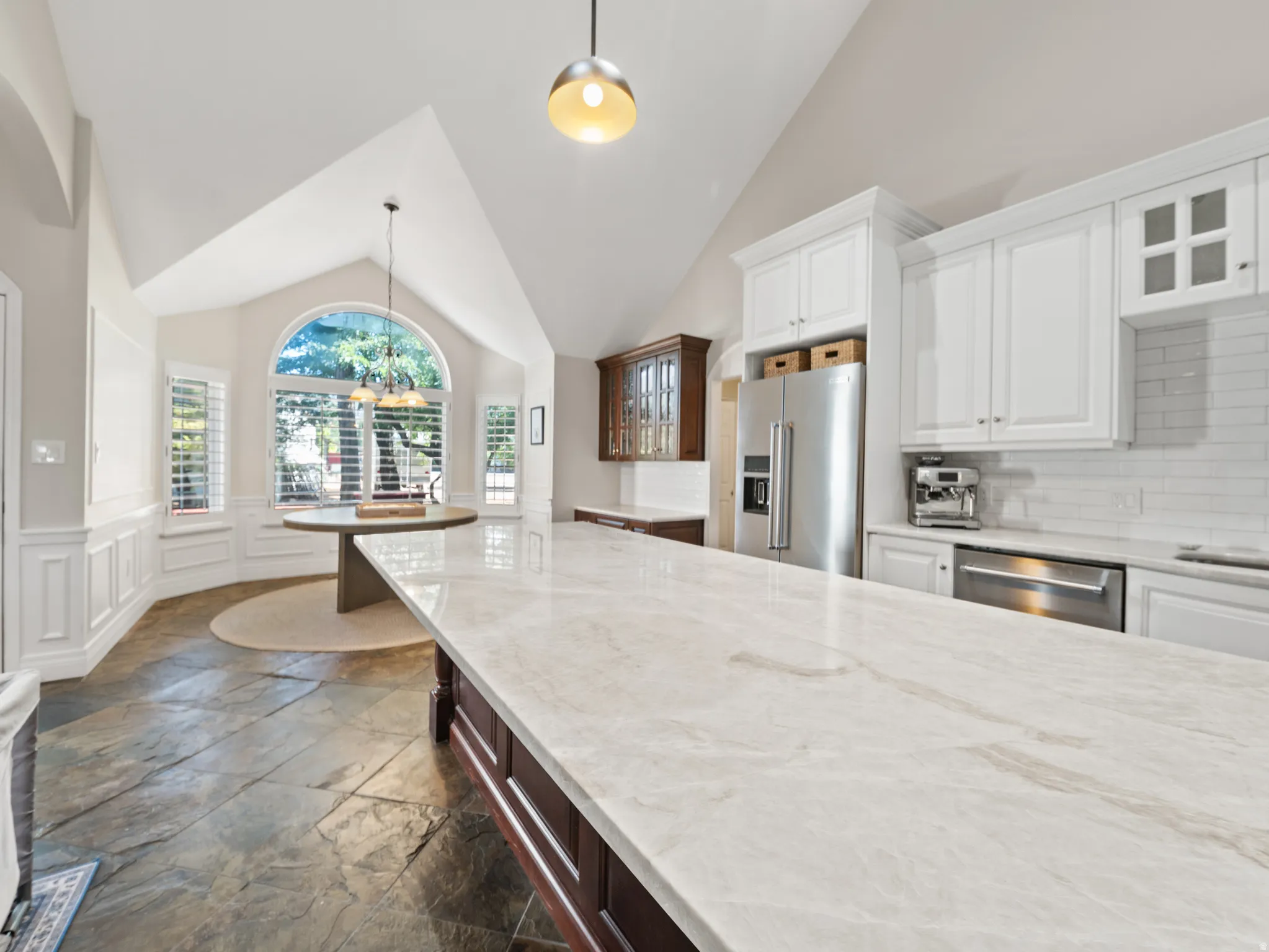 Kitchen featuring a vaulted ceiling and a large island with a light-toned countertop