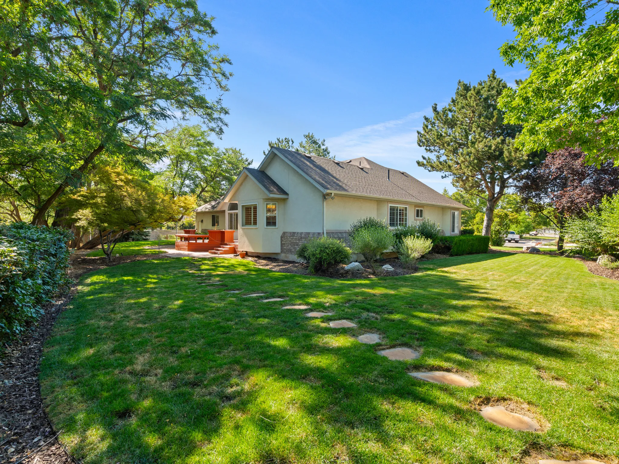 Manicured lawn with stepping stones leading to a patio