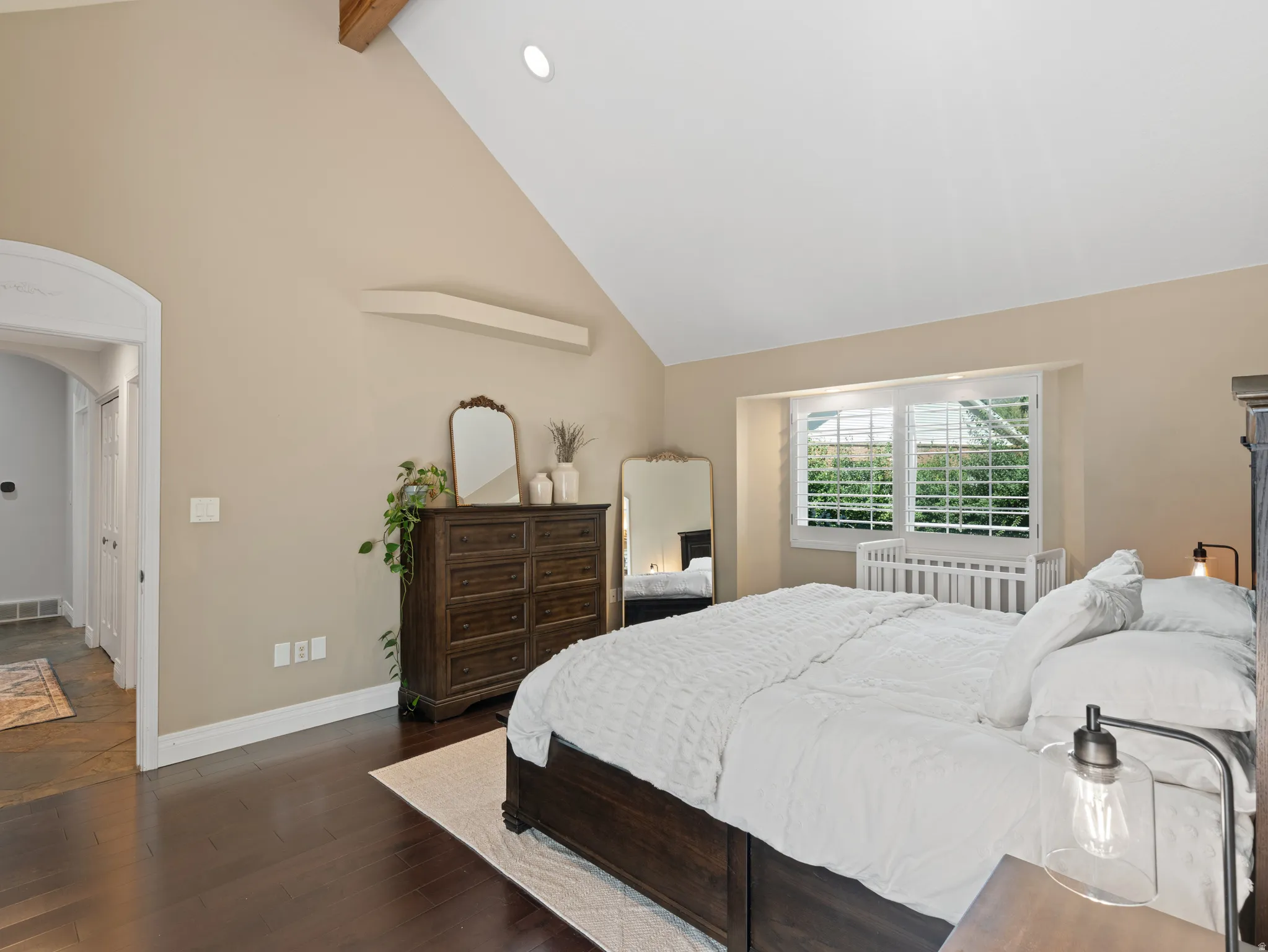 Vaulted ceiling featuring a prominent exposed wood beam and recessed lighting