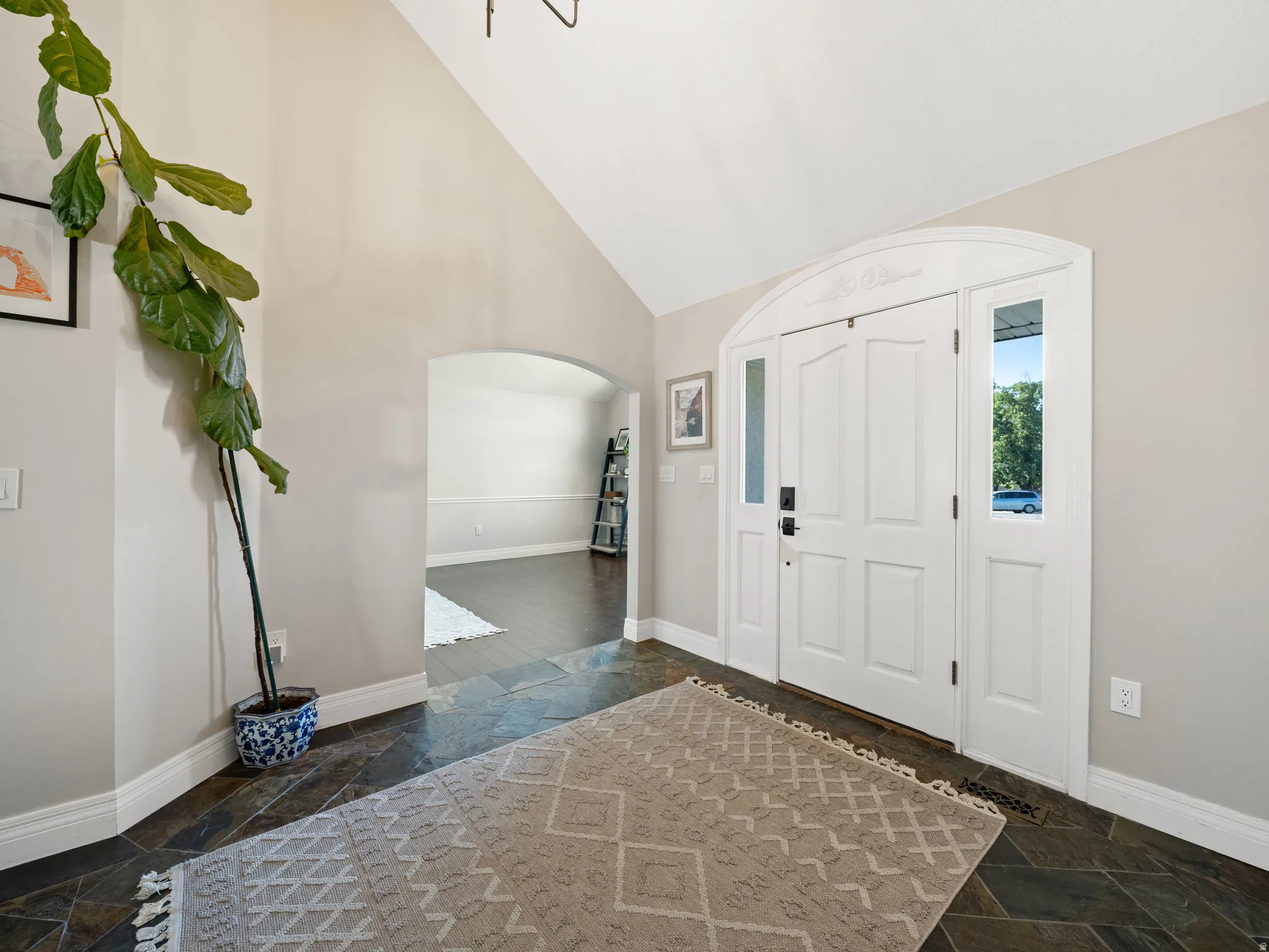 Grand entryway featuring an arched double-door system with sidelights and an upper transom window