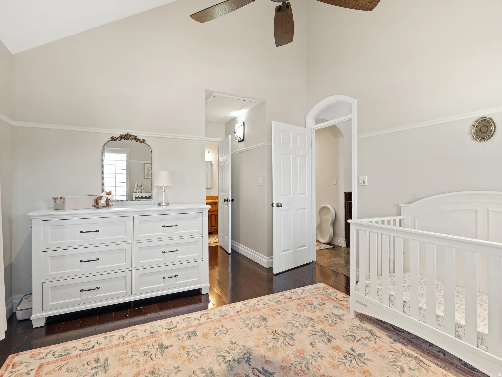 Vaulted ceiling bedroom featuring dark wood-finish flooring and light wall finishes