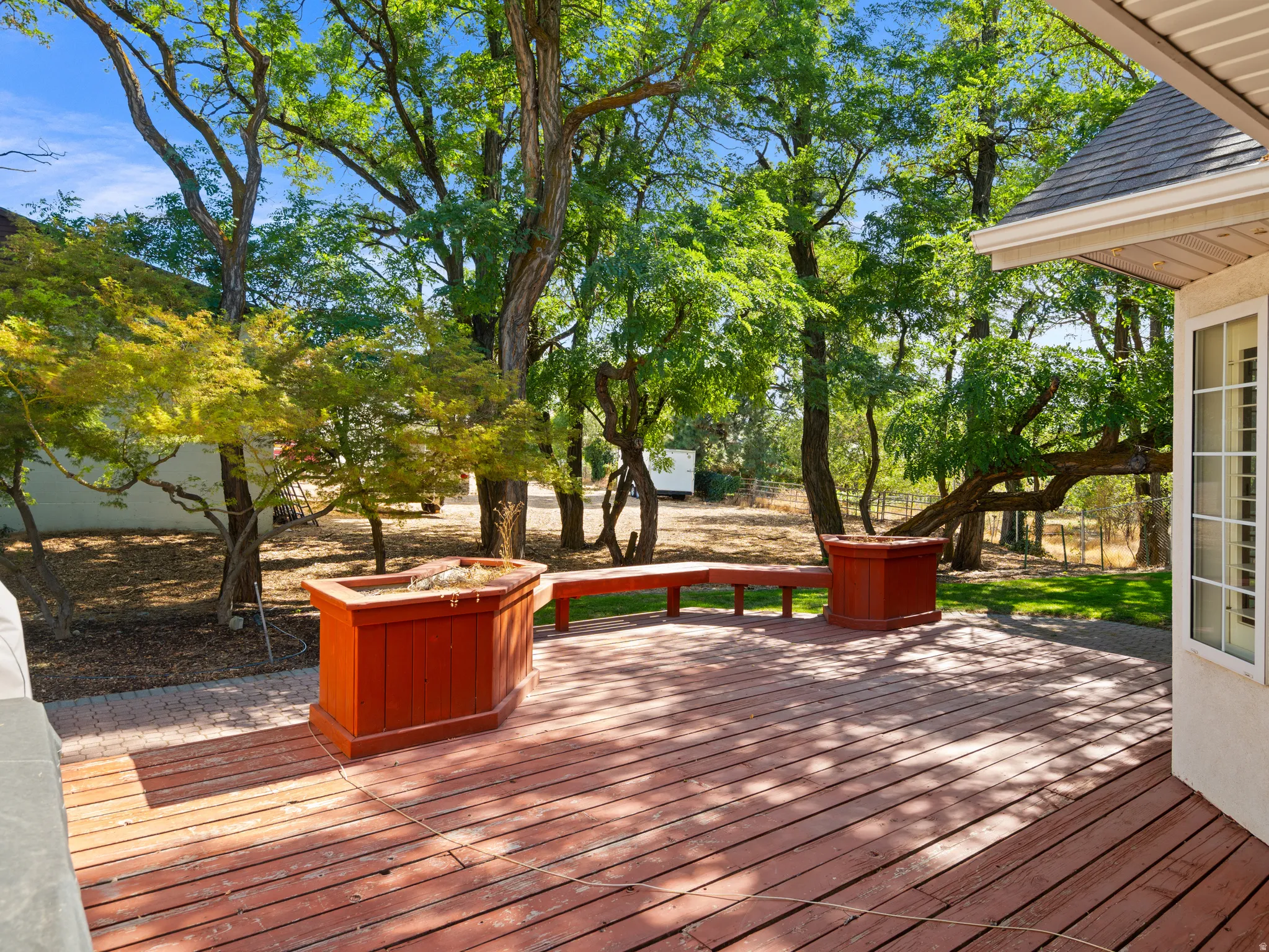 Expansive wood deck featuring built-in planters and bench seating