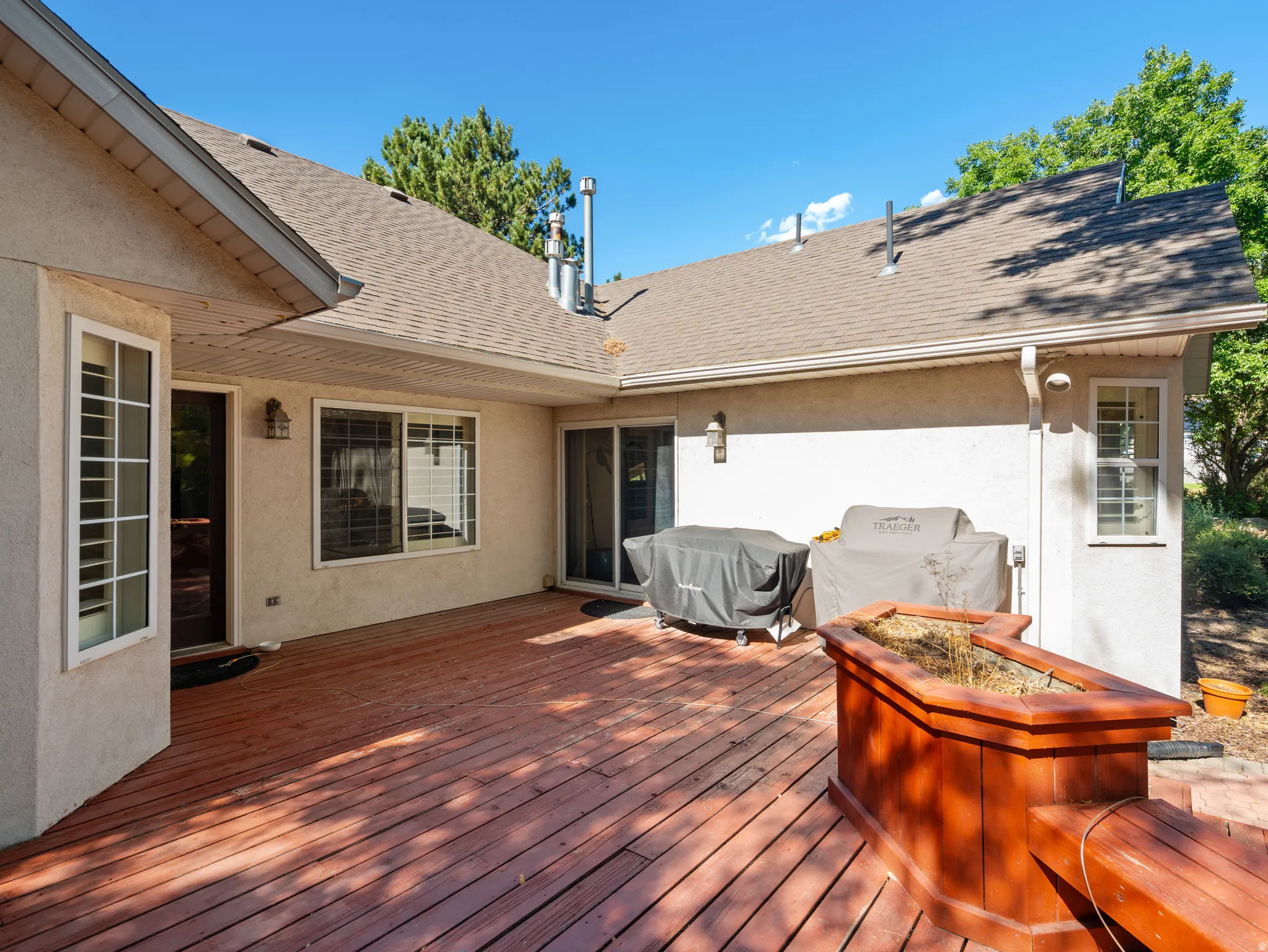 Expansive wood deck with an integrated planter box and bench seating