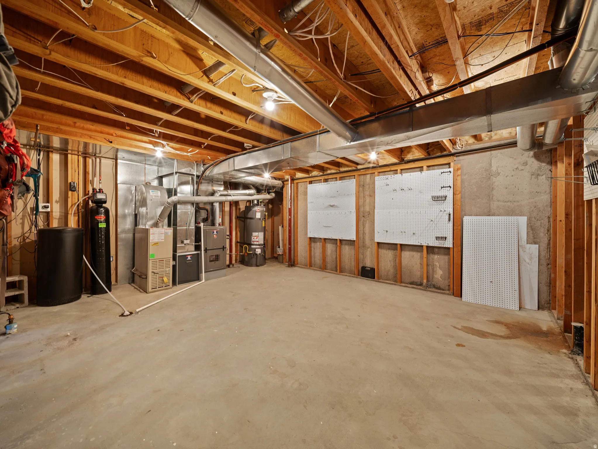 Unfinished basement featuring exposed wood joists and concrete flooring