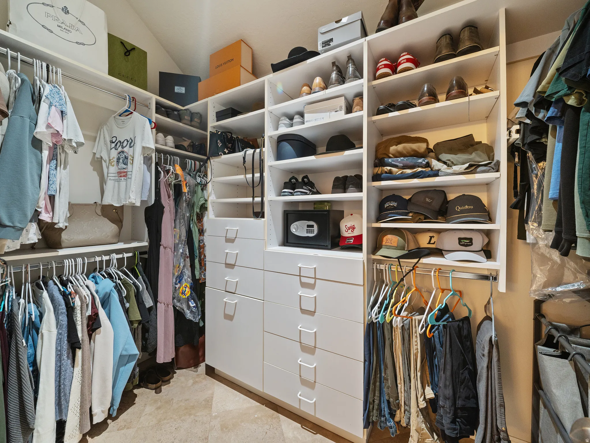 Customized closet system featuring multiple hanging rods, open shelving, and integrated drawer storage