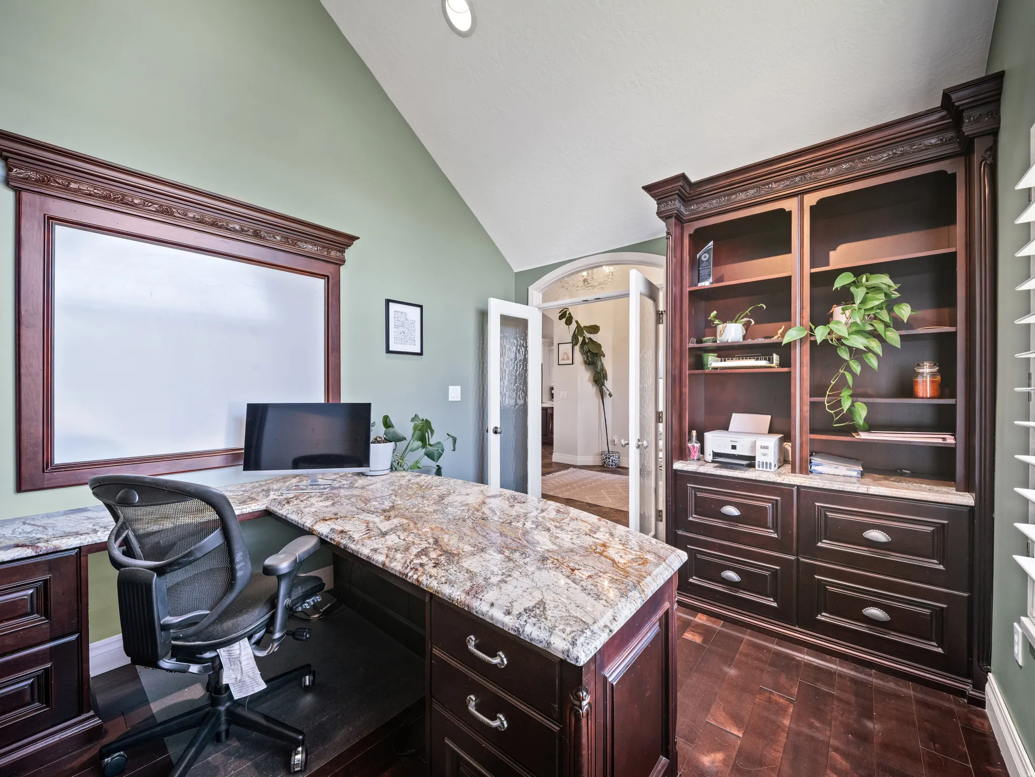 Built-in desk with a granite countertop and dark wood-finish cabinetry