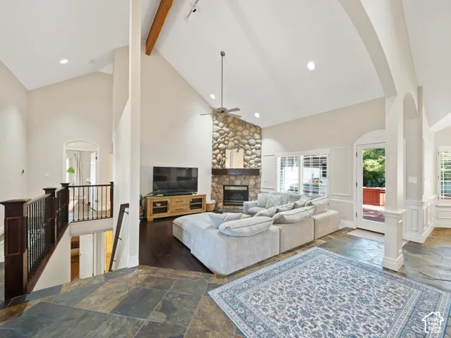 Vaulted ceilings in a spacious living area featuring a floor-to-ceiling stone fireplace