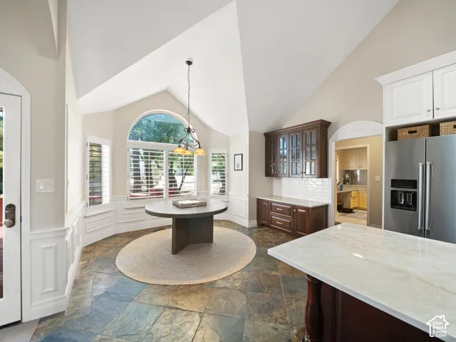 Vaulted ceiling kitchen nook featuring a half-round window with plantation shutters