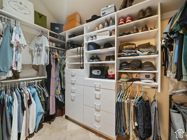 Customized closet system featuring multiple hanging rods, open shelving, and integrated drawer storage