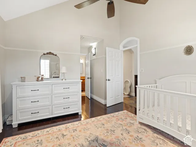 Vaulted ceiling bedroom featuring dark wood-finish flooring and light wall finishes