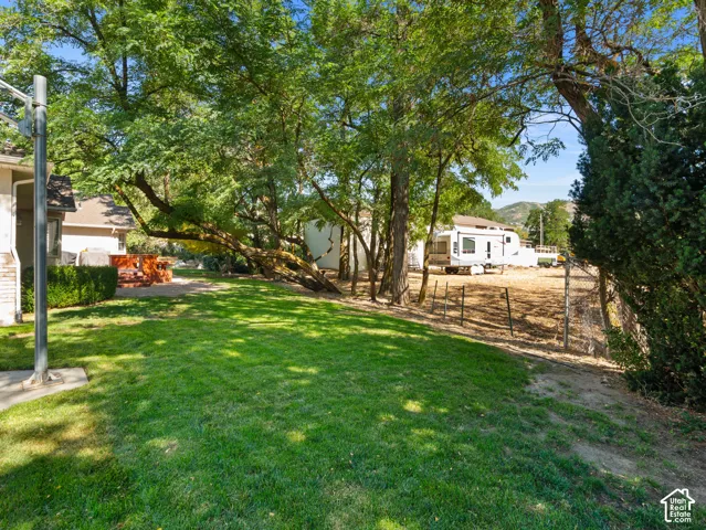 Expansive green lawn with mature trees providing shade