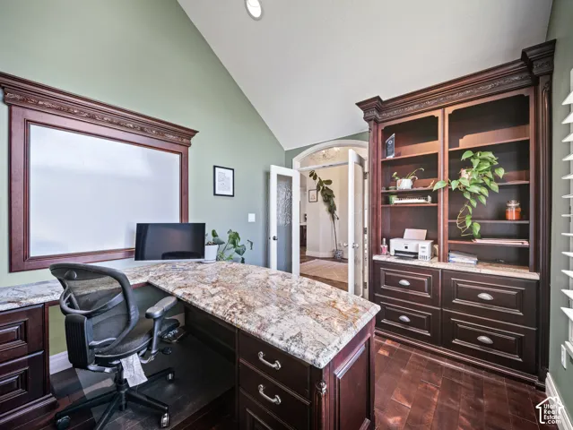 Built-in desk with a granite countertop and dark wood-finish cabinetry