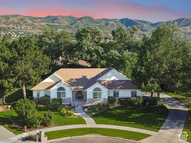 Elegant single-story residence featuring a crisp white exterior with arched entryways, dual gabled rooflines, and a composite or architectural shingle roof