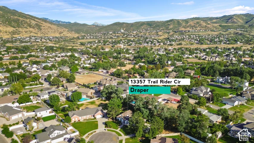 Expansive residential area featuring numerous single-family homes, mature trees, and a mountain backdrop