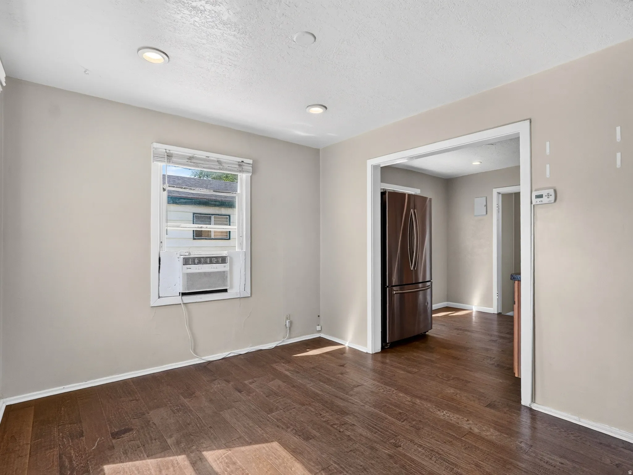 Interior space featuring wood-finish flooring, light neutral-toned walls, and recessed ceiling lighting
