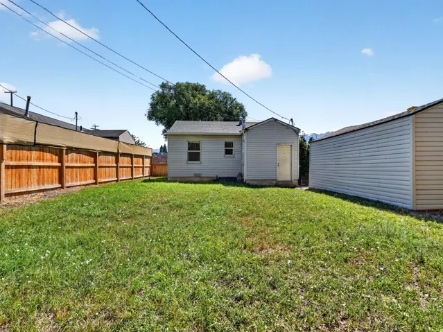 Expansive grassy yard with a wooden privacy fence